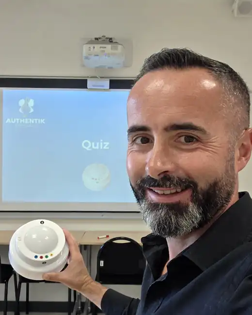 David Guirriec, formateur, avec un buzzer de quiz en salle de formation